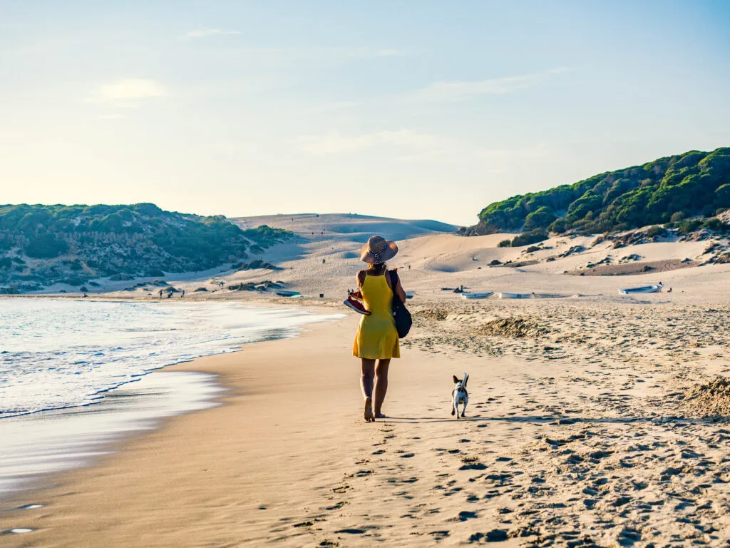 žena na procházce se psem na pláži bolonia