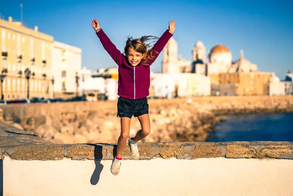 dítě skákající v pozadí katedrála v cádiz